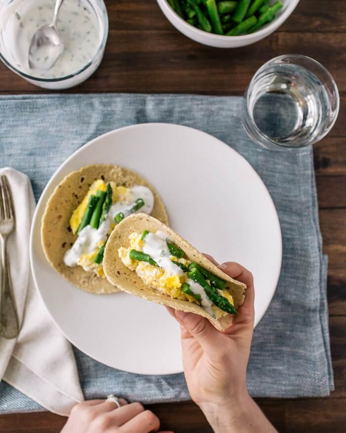 Scrambled Egg Tacos with Ricotta and Asparagus |  A couple is cooking