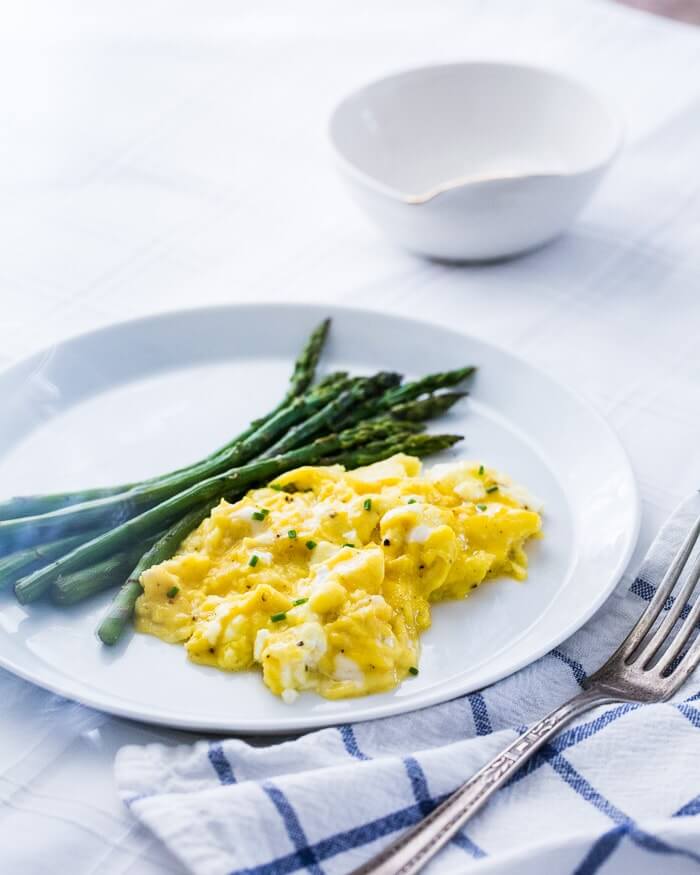 Fluffy scrambled eggs with asparagus on a plate